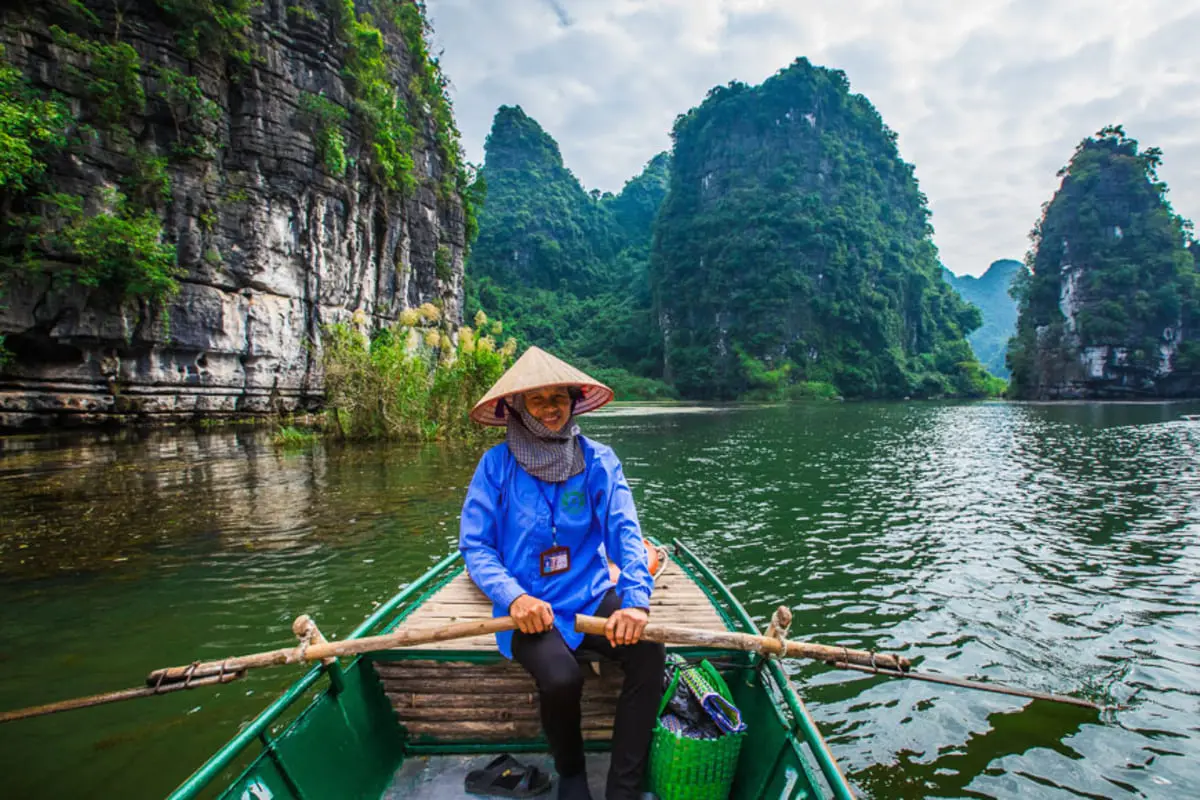 Boat ride through limestone scenery at Trang An in Ninh Binh